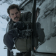 Yes, that’s Henry Cavill, with a machine gun, in a helicopter, flying through the mountains.